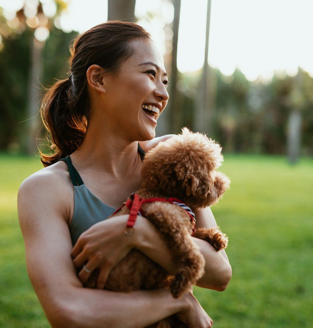 Patelco member Judy F. holds her small dog.